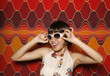 Woman smiling while adjusting her sunglasses