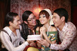 Woman making birthday wish, men watching