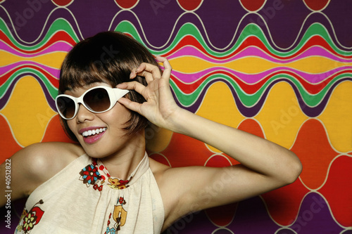 Photo: Woman smiling while adjusting her sunglasses Woman smiling while adjusting her sunglasses