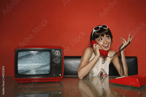 Photo: Woman using rotary phone Woman using rotary phone
