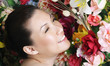 Woman posing in front of floral background