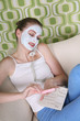 Woman with facial mask filing her fingernails while talking on the phone