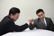 Businessmen arm wrestling