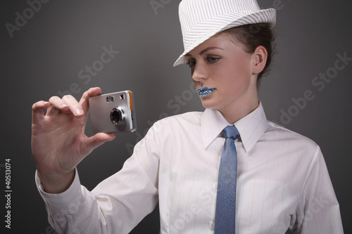Foto: Woman with rhinestones on her lips taking picture with digital camera Woman with rhinestones on her lips taking picture with digital camera