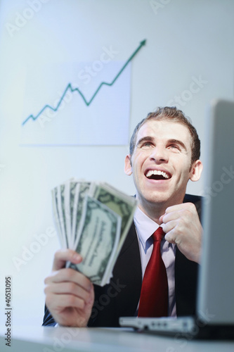 Foto: Businessman smiling while holding banknotes Businessman smiling while holding banknotes