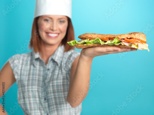 Photo: chef holding a big sadwich in hand chef holding a big sadwich in hand