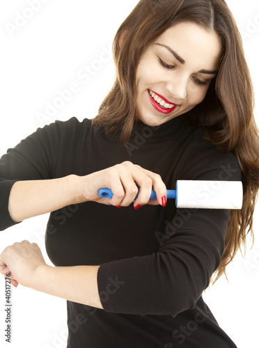 Photo: young woman cleaning dust with lint roller young woman cleaning dust with lint roller