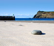 Detail of Stone on a Sand Beach with Sea Detail of Stone on a Sand Beach with Sea