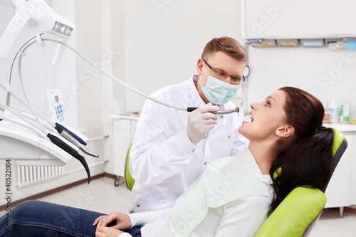 Photo: The dentist treats teeth of patient The dentist treats teeth of patient