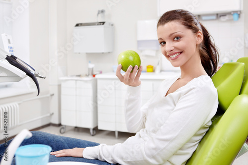 Photo: A girl with an apple in dentistry A girl with an apple in dentistry