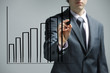 Foto: Businessman drawing a uptrend chart on screen Businessman drawing a uptrend chart on screen