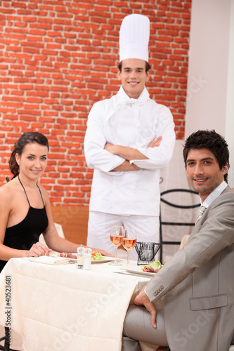 Photo: Chef stood with couple in restaurant Chef stood with couple in restaurant