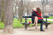 Happy romantic couple hugging and kissing on a bench