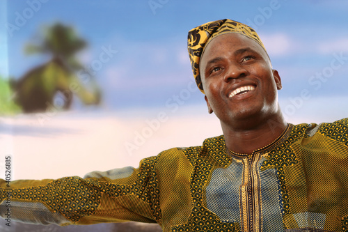 Photo: A smiling black man on the beach is looking upwards A smiling black man on the beach is looking upwards