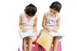 Two Indian kids doing their homework. Girl cheating.