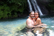 Happy couple bathing near waterfall in island