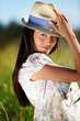 Gypsy girl with hat standing in field of wild flowers Gypsy girl with hat standing in field of wild flowers