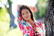 Beautiful woman standing by a tree in countryside Beautiful woman standing by a tree in countryside