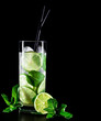 Mojito cocktail on black background with lime and mint with copy