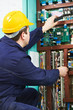 Electrician checking current at power line box