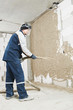 Plasterer at stucco work with liquid plaster