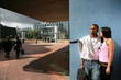 Young couple stood by large city building