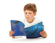 Foto: A serious boy is reading a book lying on the floor A serious boy is reading a book lying on the floor