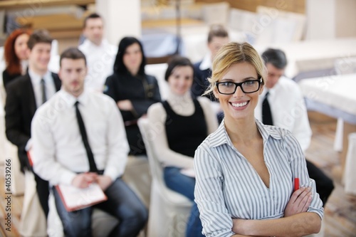 Photo: business woman standing with her staff at conference business woman standing with her staff at conference