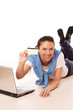 A young woman lying on the floor with a laptop