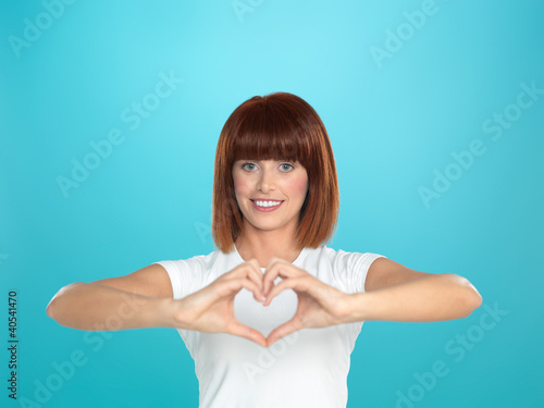 Photo: woman smiling making heart shape with hands woman smiling making heart shape with hands