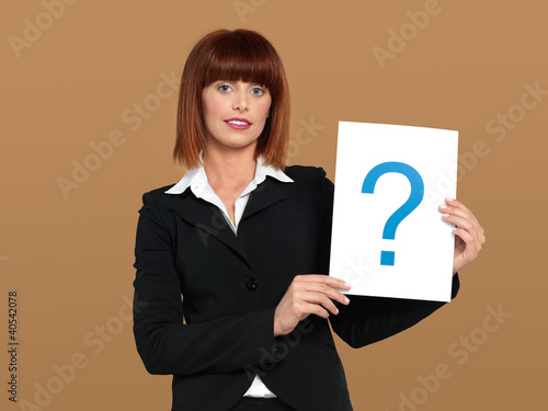 Photo: pretty, young businesswoman holding question mark sign pretty, young businesswoman holding question mark sign