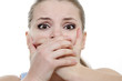 young horrified woman closing her mouth with hands over white