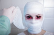Doctor taking off bandage from scary patient