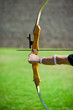 Archer who holds his bow aims at target