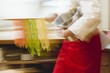 Chef with home-made coloured ribbon pasta and pasta pan