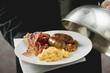 English breakfast on plate with dome cover