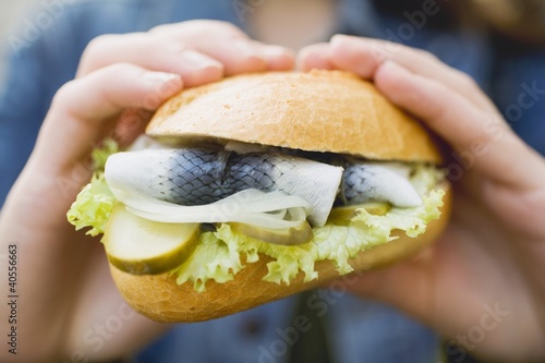 Photo: Hands holding a fish roll Hands holding a fish roll