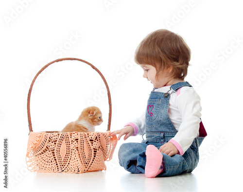 Photo: Smiling child sitting down by basket with kittens, isolated on w Smiling child sitting down by basket with kittens, isolated on w
