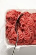 Fresh minced beef in plastic container with spoon