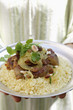 Photo: Person serving lamb ragout with almonds, raisins, couscous Person serving lamb ragout with almonds, raisins, couscous