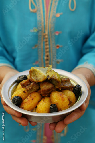 Foto: Person holding bowl of lamb ragout and potatoes (Morocco) Person holding bowl of lamb ragout and potatoes (Morocco)