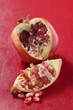 Pomegranate, cut open, on red background