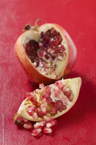 Photo: Pomegranate, cut open, on red background Pomegranate, cut open, on red background
