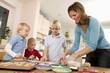 Photo: Mother and three children baking biscuits Mother and three children baking biscuits