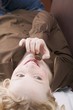 Young woman on sofa eating a chocolate