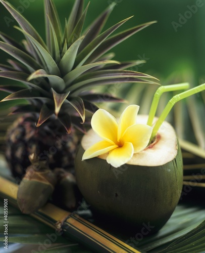 Foto: Opened coconut with straws and a pineapple Opened coconut with straws and a pineapple