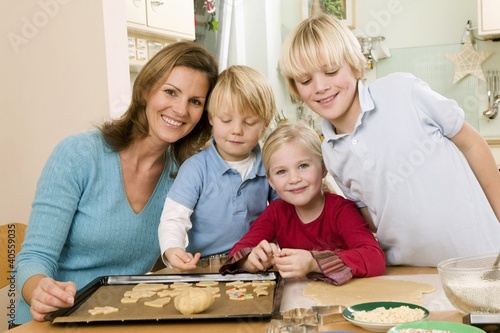 Photo: Mother and three children baking biscuits Mother and three children baking biscuits