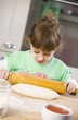 Foto: Small girl rolling out pizza dough Small girl rolling out pizza dough