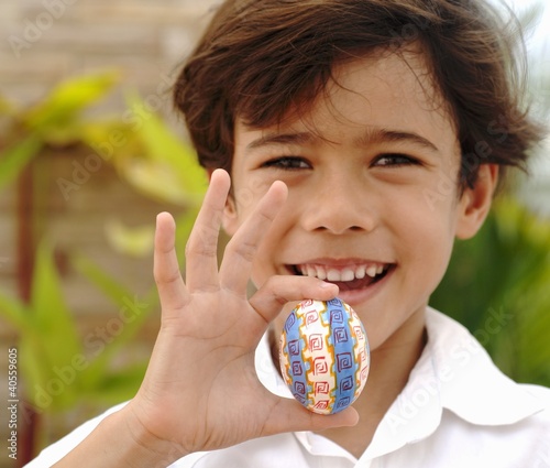 Photo: Boy holding an Easter egg in his hand Boy holding an Easter egg in his hand
