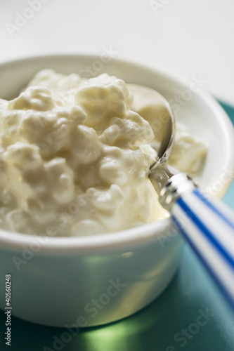 Photo: Cottage cheese in a small bowl with spoon Cottage cheese in a small bowl with spoon